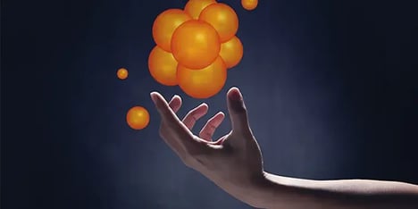 Hand met daarboven meerdere zwevende oranje ballen