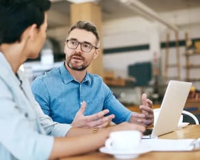 Twee mannen in gesprek achter een laptop