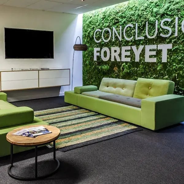 Groene bank tegen wand met logo van Conclusion ForeyeT