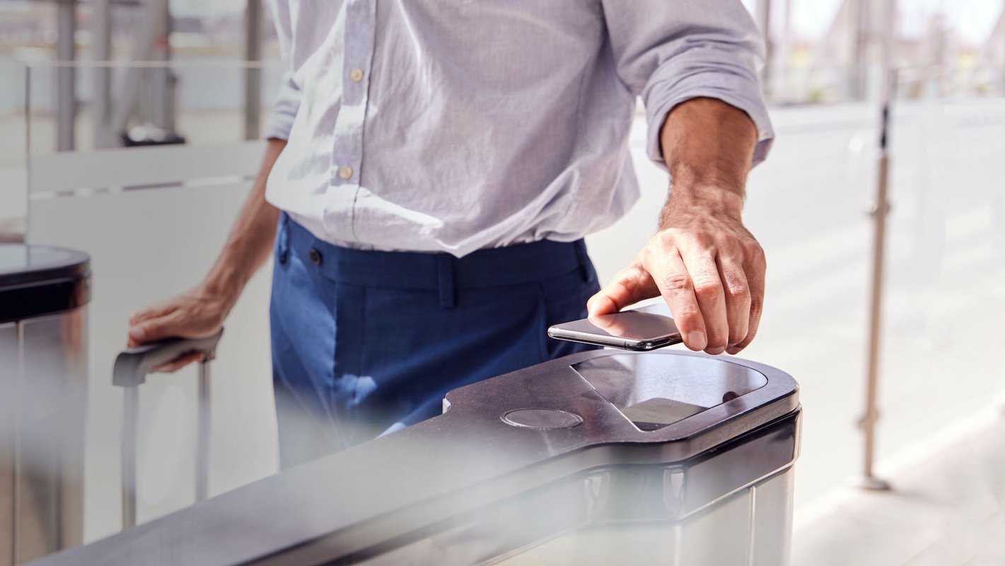 man scant met telefoon toegangspoortje