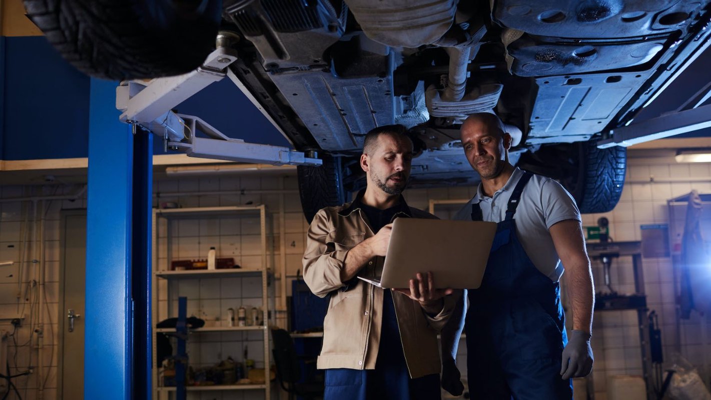 twee mannen in een garage die kijken naar een laptop