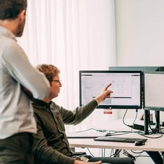Collega's in gesprek, een wijst naar scherm