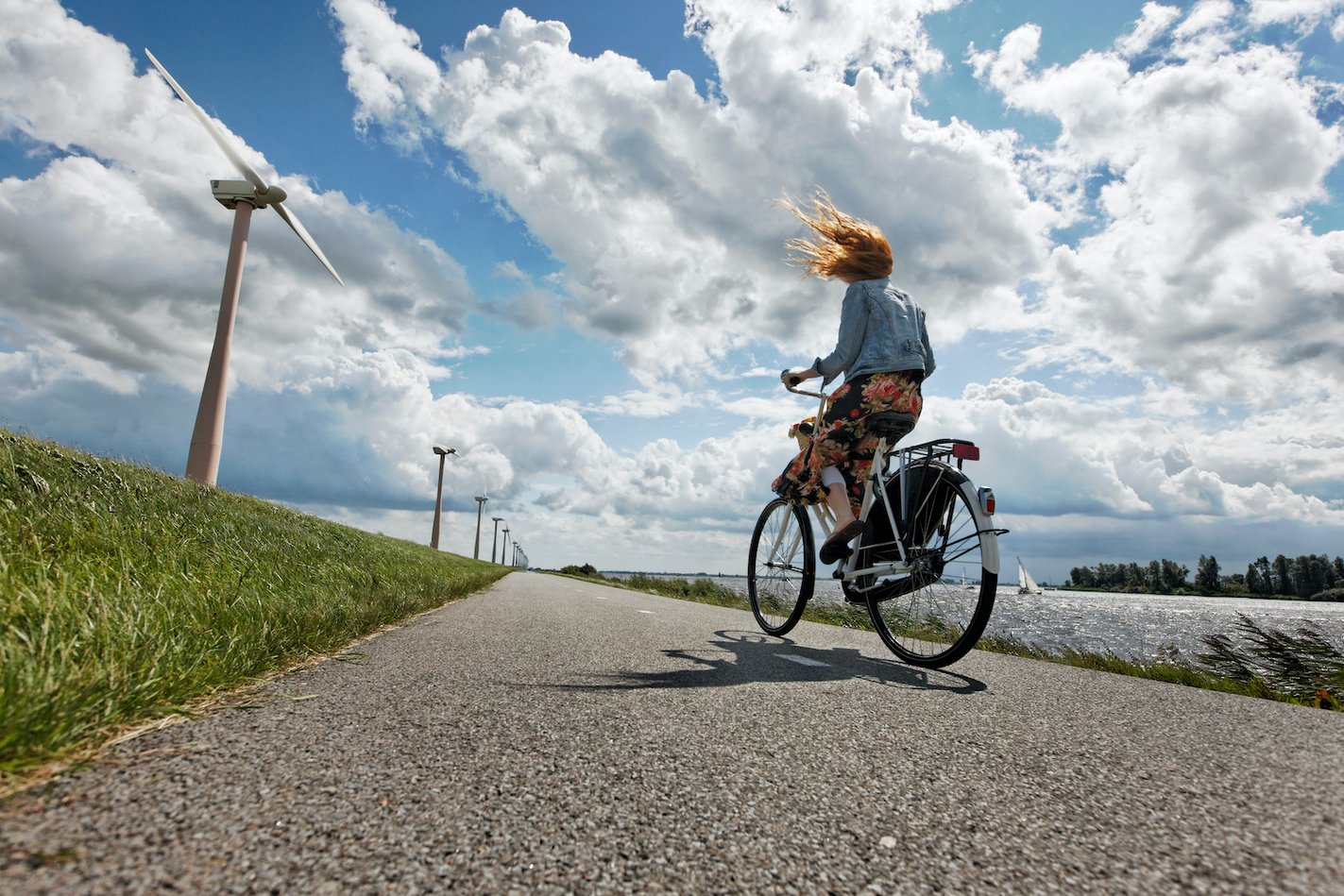 vrouw op fiets in de wind