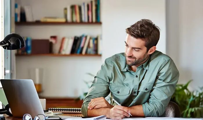 Man schrijft aan tafel 