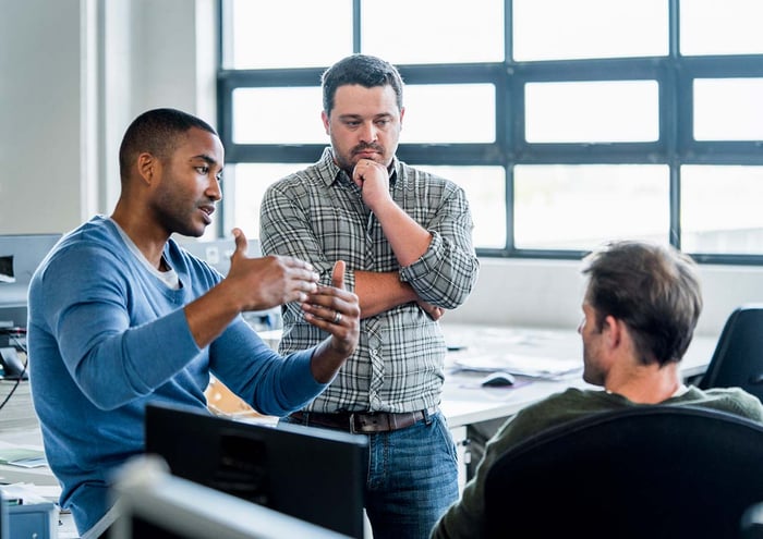 3 collega's praten met elkaar