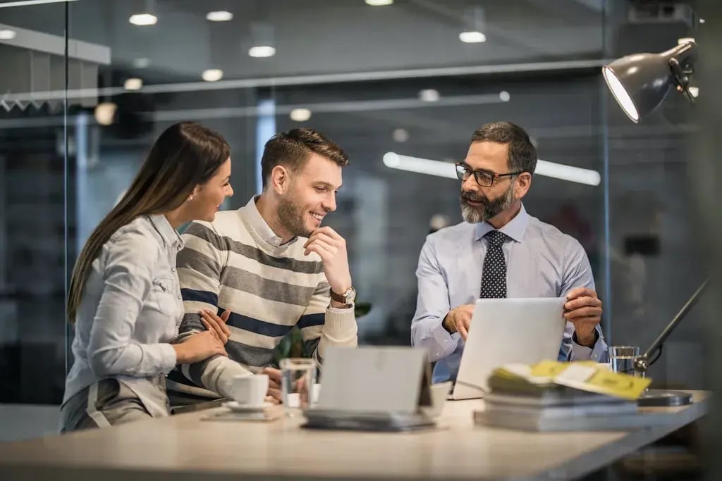 Drie collegas kijken naar een scherm