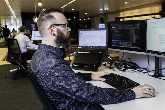 A man working behind two screens