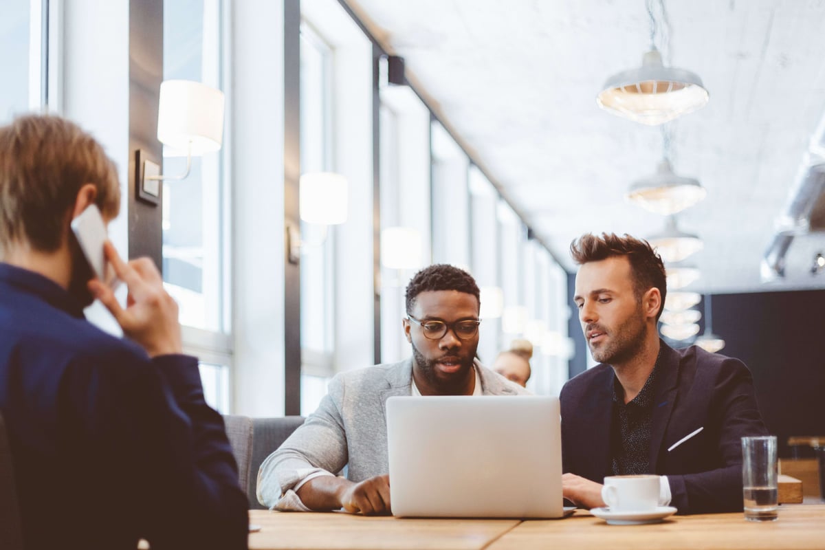 Drie mannen aan het werk aan een tafel