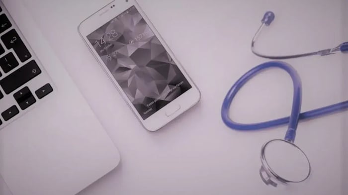 Laptop met daarnaast een telefoon en stethoscoop