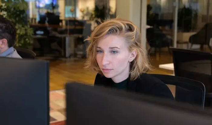 Vrouwelijke collega achter een computerscherm.