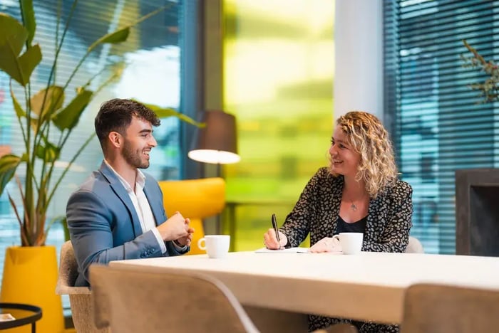 Twee collega's in een kantoorgebouw.