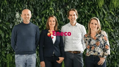 vier mensen lachend naast elkaar tegen groene achtergrond