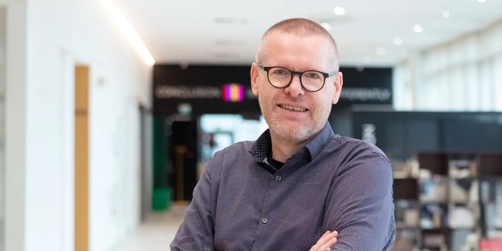 Rene Altena smiles into the camera and his arms crossed