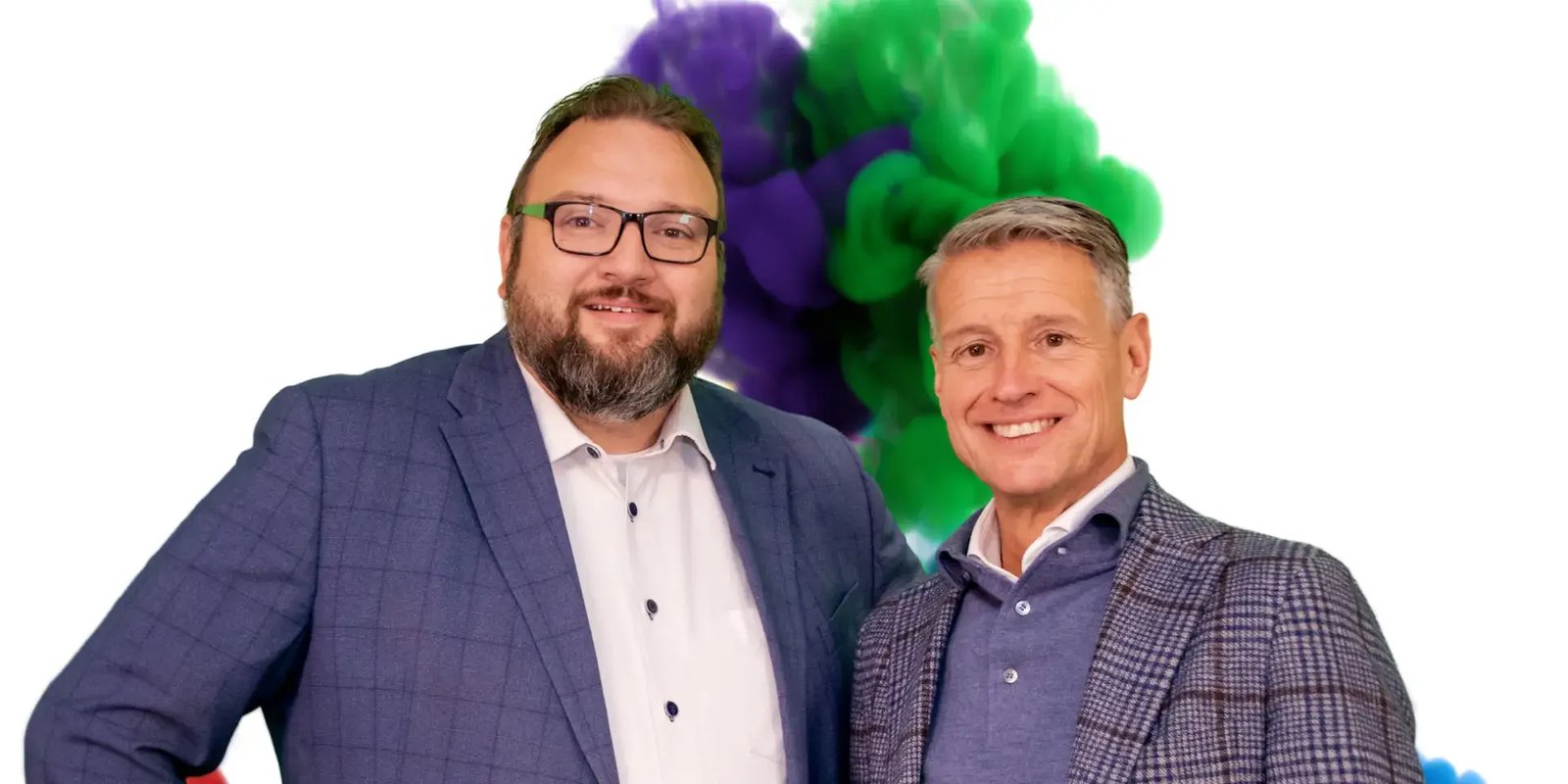 Twee mannen staan voor een explosie van paars en groen vuur