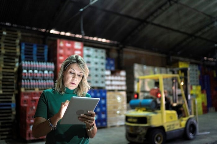 A woman with a tablet in a warehouse.