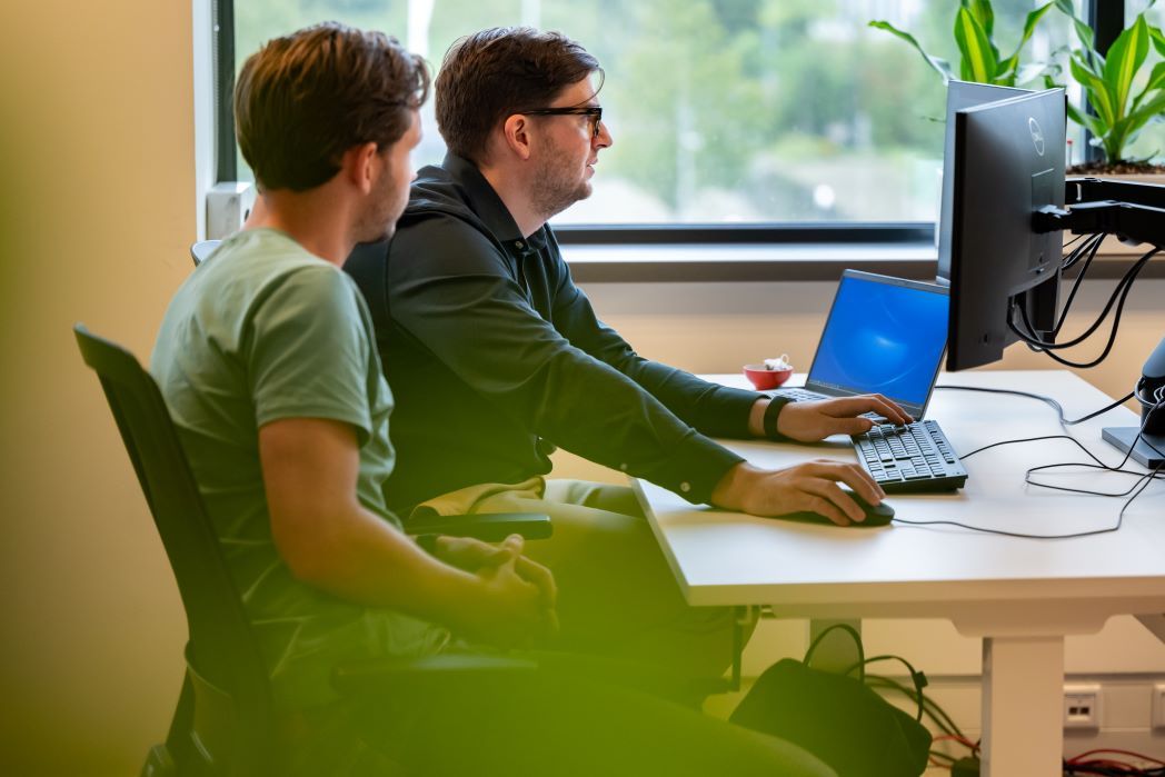 Collega's aan het wer achter computers