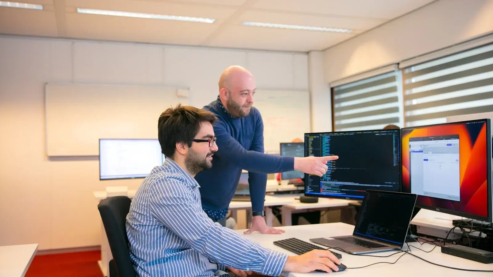 Twee mannen discussieren over data informatie op een scherm