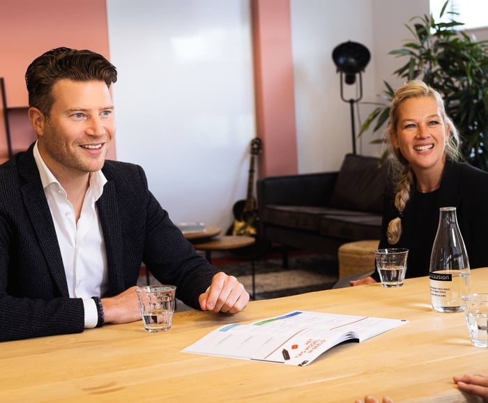 Twee collega's lachen met elkaar.