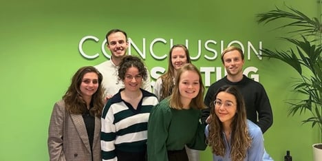 Groepsfoto voor een groene muur