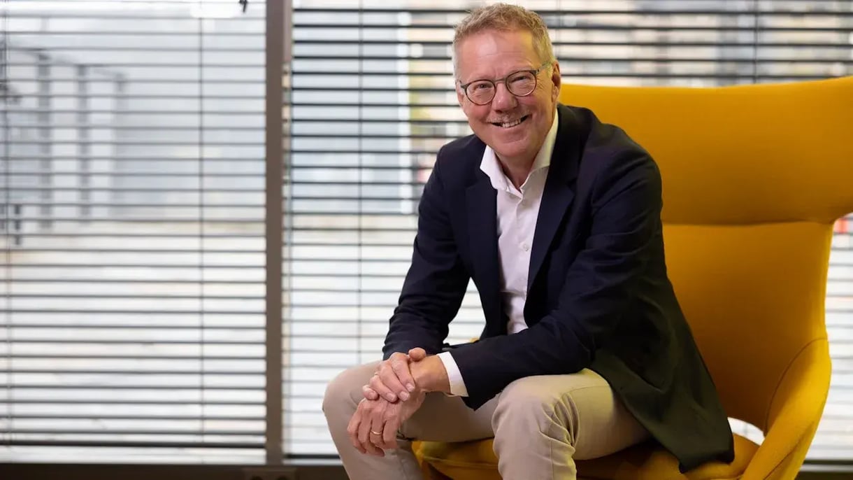 Bert Jan de Jongh die zittend op een gele fauteuil in de camera kijkt