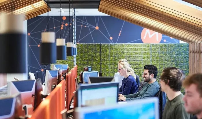 Colleagues are working next to each other and are having a laugh.