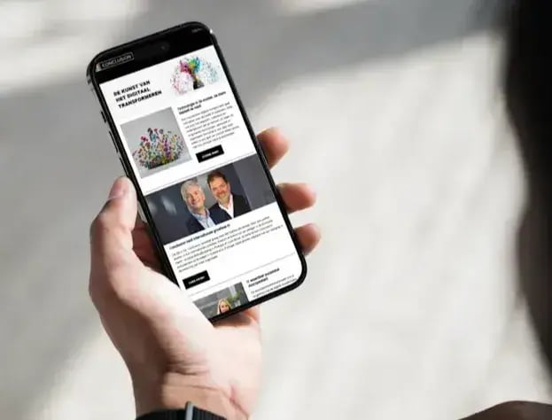 A phone in someone's hand, depicting the Conclusion Newsletter