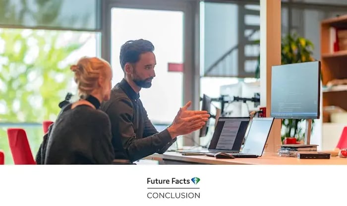 A male and female colleague with laptops.
