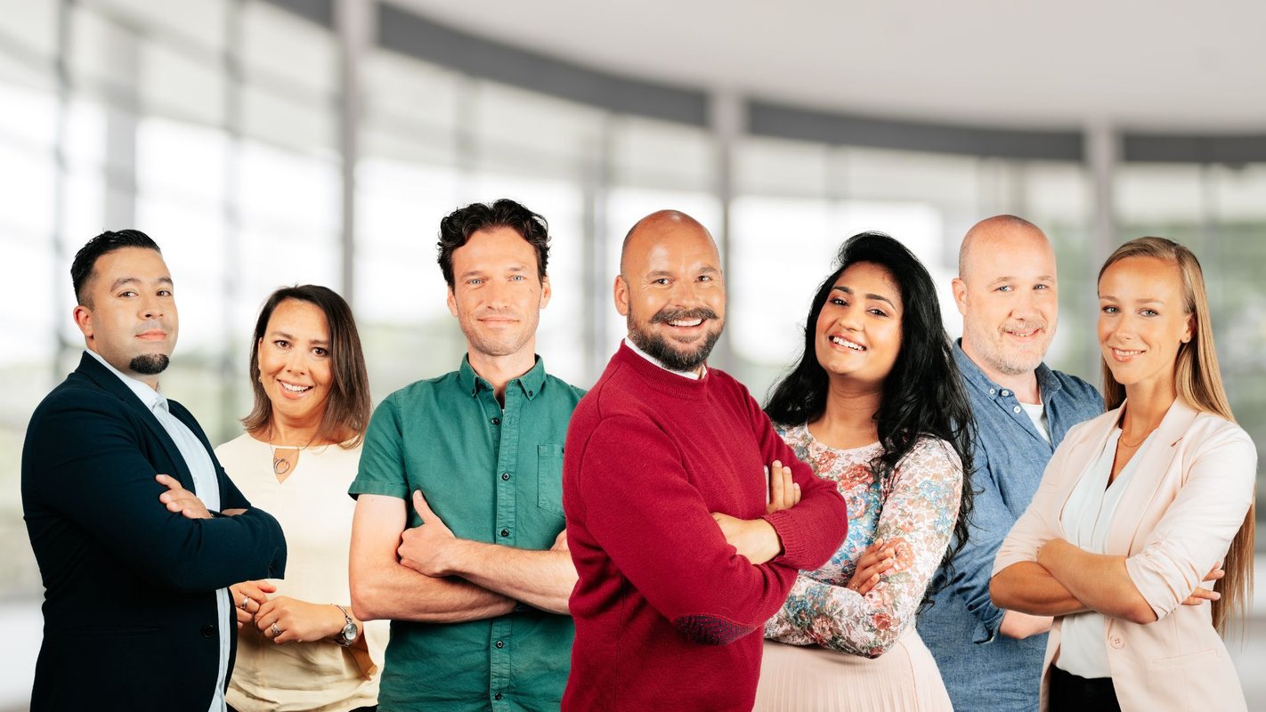 Een groep collegas kijken trots naar de camera