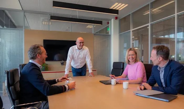 Colleagues are sitting at a desk and discussing.