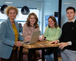 Collega's leunen op statafel en lachen.