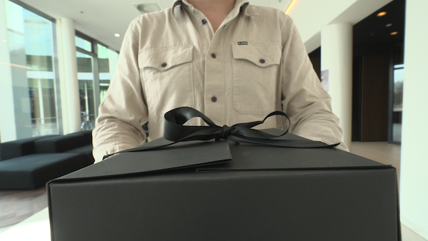 Collega rijkt een cadeau uit.