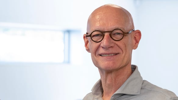 Een lachende man met bril