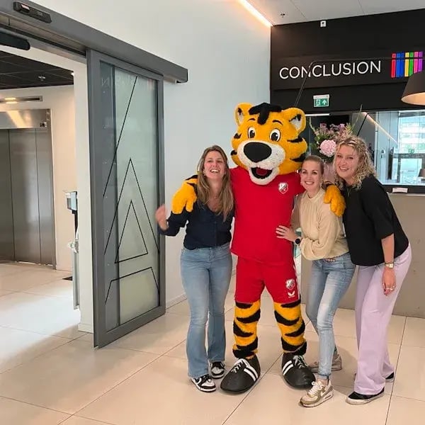 Colleagues from Conclusion are posing with FC Utrecht’s mascot.