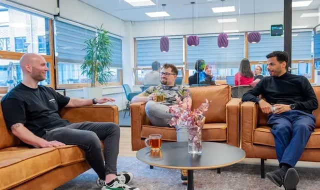 Mensen zitten in stoelen met elkaar te praten.