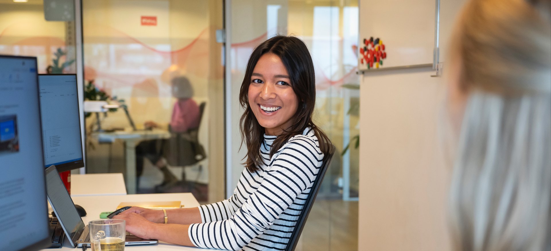 Vrouwelijke collega achter een computer.