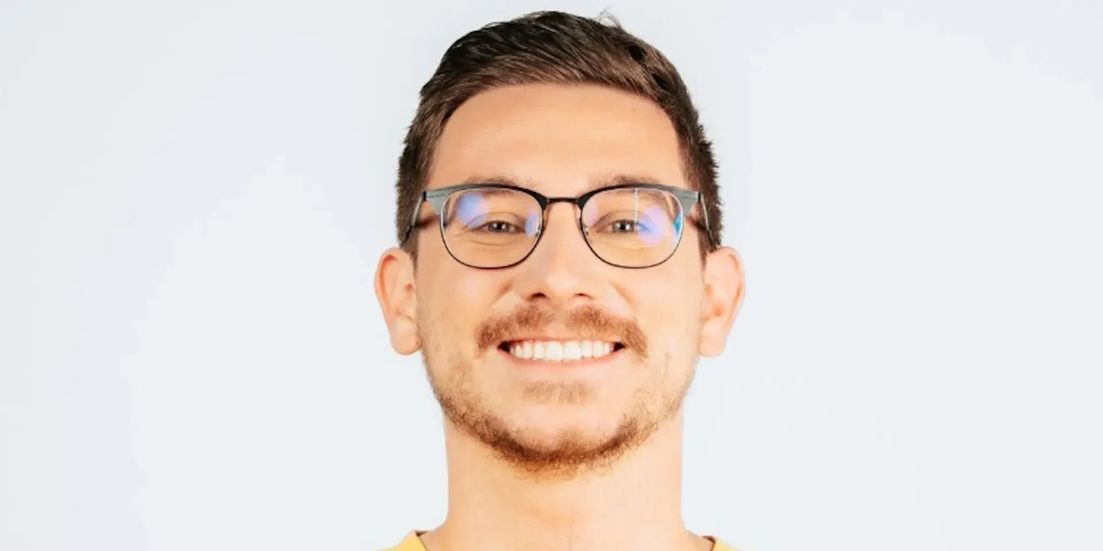 Photo of a smiling man with glasses.