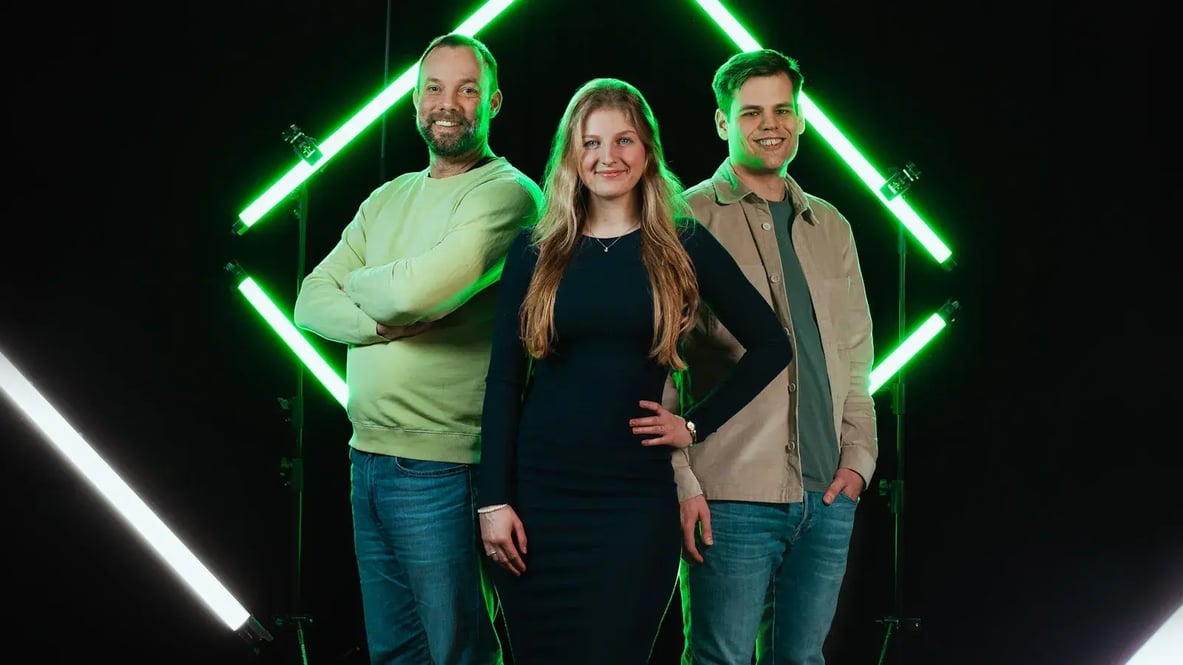 Drie medewerkers van Conclusion Integrations tegen een zwarte achtergrond met groene lichten