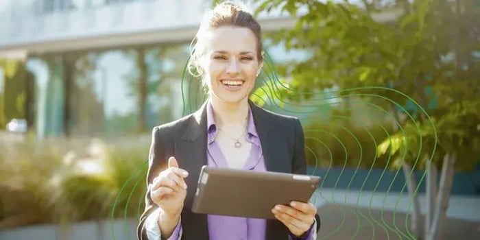 A consultant holding a tablet outside