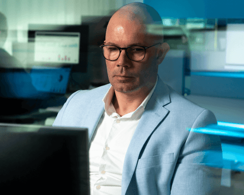 Mannelijke collega kijkt gefocust naar zijn scherm.