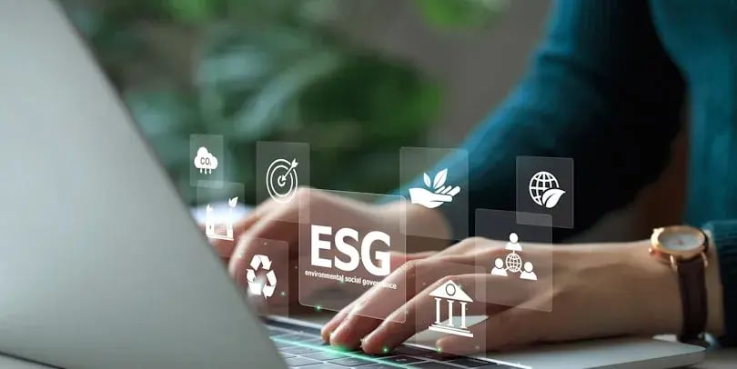 Handen die op het toetsenbord van een laptop typen met een overlay met duurzame iconen