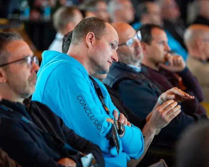 Mannelijke collega luistert aandachtig bij een event.