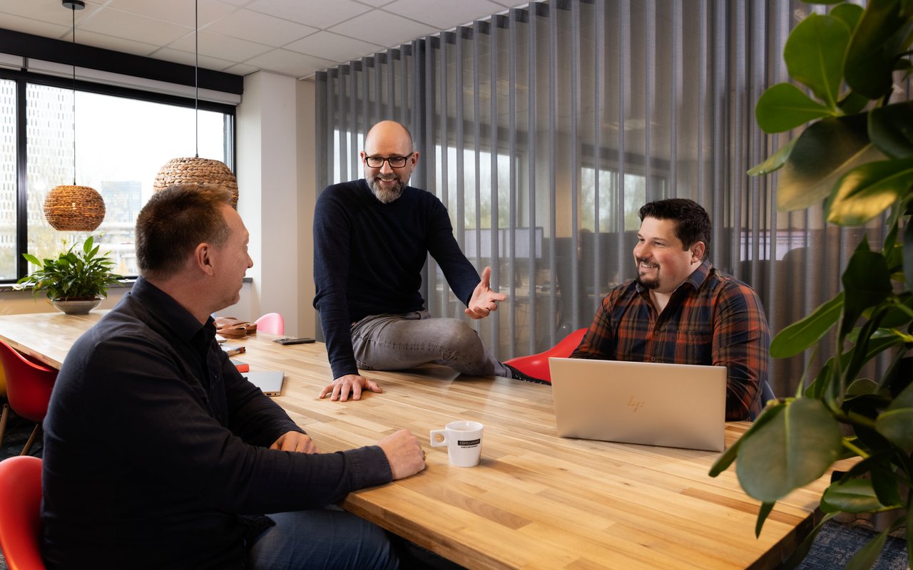 Mannen zitten rond laptop