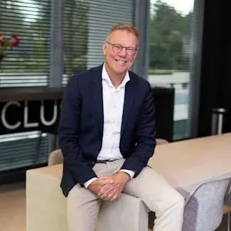 Bert Jan de Jongh die op de hoek van een bank zit en lachend in de camera kijkt