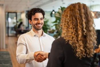 Lachende man schud vrouw de hand