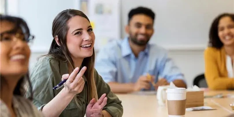 Collegas lachen met elkaar aan tafel