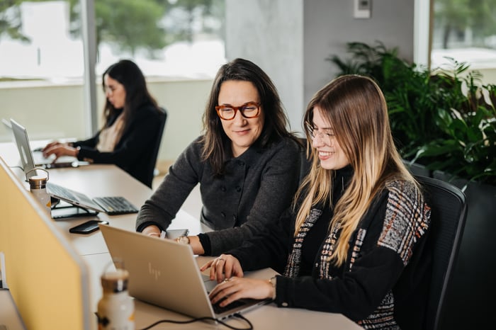 Twee vrouwen die voor een laptop zitten