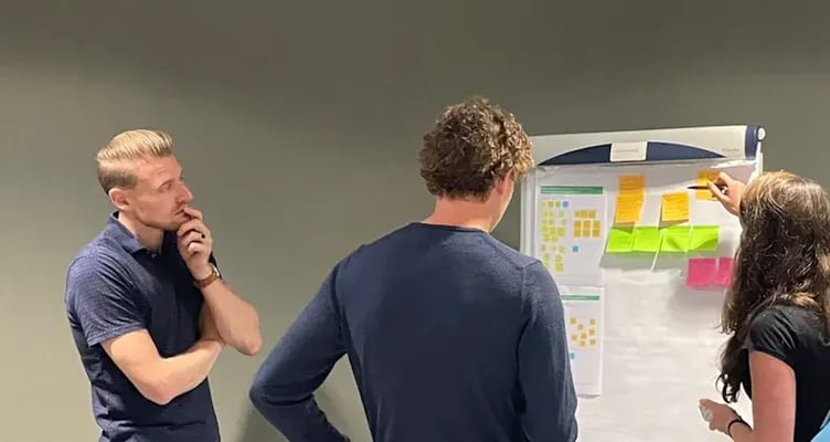 Drie collegas kijken naar wat notes