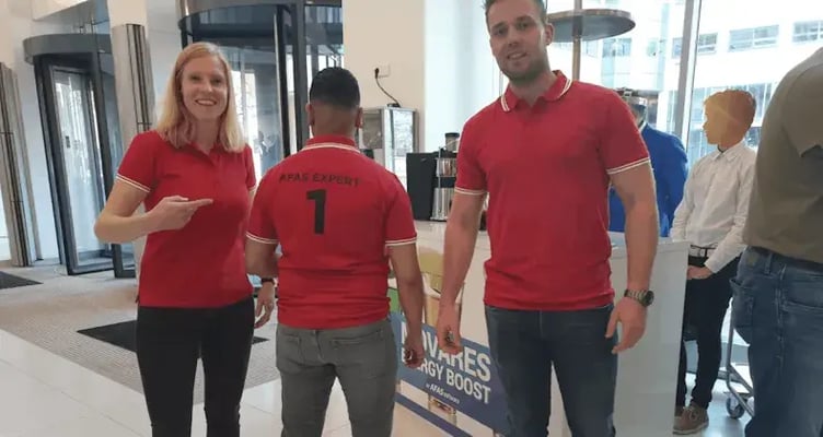 Drie collegas poseren voor een foto, eentje laat zijn rug zien