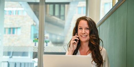 Een dame zit lachend te bellen