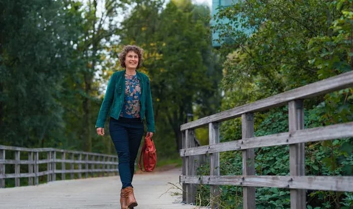 Een mevrouw loopt op een brug